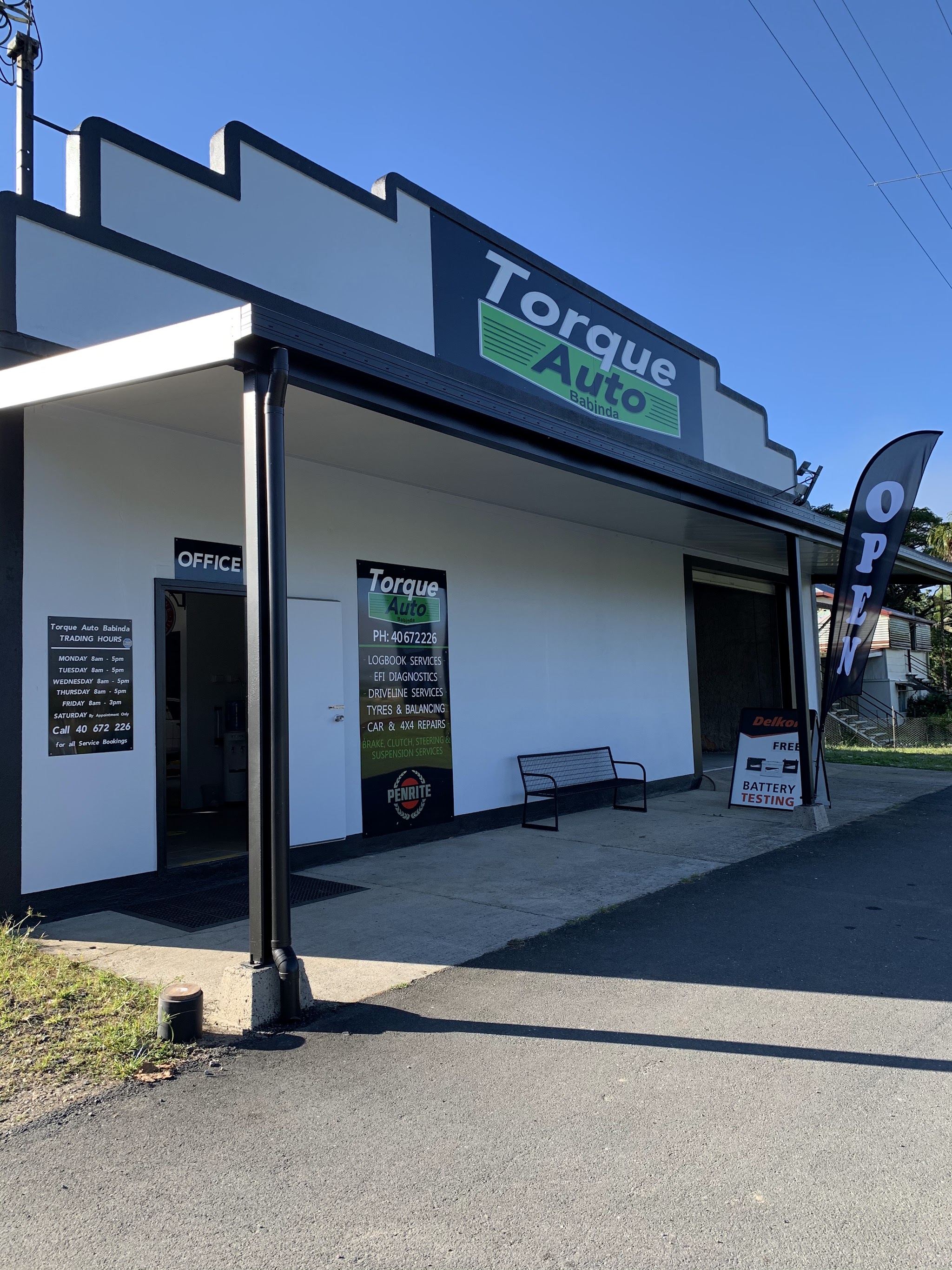 The Torque Auto Babinda workshop on Howard Kennedy Drive, with the trading hours and service board beside the office door
